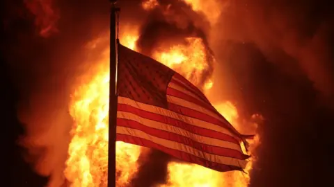 Getty Images A flag outside a Department of Corrections building that burned in the protests