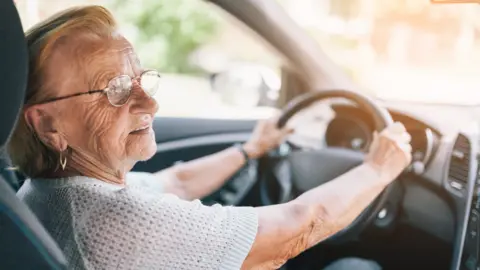 Getty Images A woman behind the steering wheel of a car
