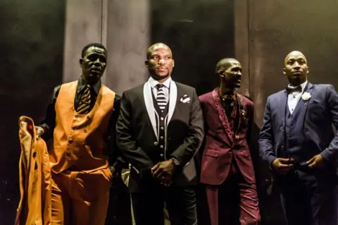 AFP Traditional Isicathamiya competitors prepare backstage to display their sense of style and fashion in the funky category known as 'Oswenka' (Swank), at the Natal Playhouse Theatre in Durban on September 23, 2018, during an Isicathamiya competition. - The National Isicathamiya Competition held annually includes over 150 groups competing in the Isicathamiya style, an a capella choral singing style developed in South Africa by migrant Zulu communities.