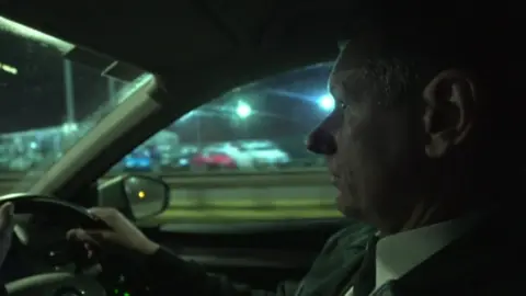 Insp Cavanagh driving a police car