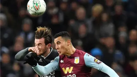 Getty Images Leicester City's English defender Ben Chilwell (L) vies in the air to header the ball with Aston Villa's Dutch striker Anwar El Ghazi during the English League Cup semi-final second leg football match between Aston Villa and Leicester City at Villa Park in Birmingham, central England on January 28, 2020.