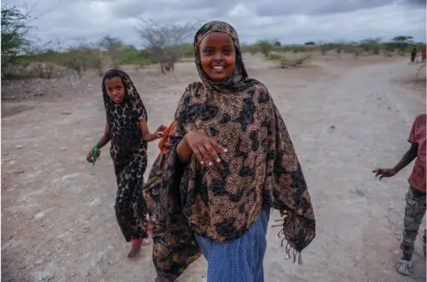 Getty Images Girl standing in arid land smiling