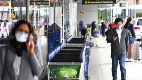 EPA People wear masks at Melbourne's airport, Australia. Photo: 13 March 2020