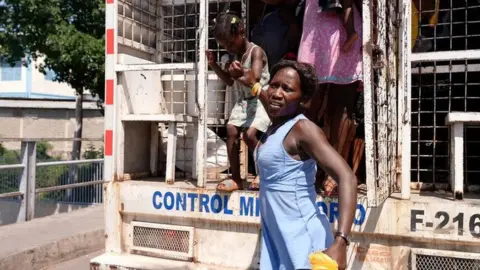 Haitians get off a lorry carrying undocumented migrants to the border