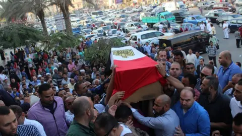 Reuters Mourners carry the coffin of a police officer killed in a shoot-out with militants in Egypt's Western Desert (21 October 2017)
