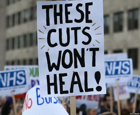 Getty Images A placard from an NHS protest saying: "These cuts won't heal"