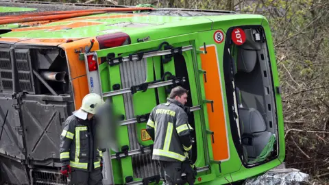 A coach lies overturned on its side at the scene of an accident on the A9 near Leipzig, Germany