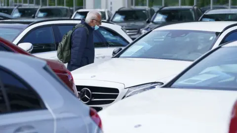 Getty Images A man looking at cars for sale at a dealership in Germany on 5 May 2020