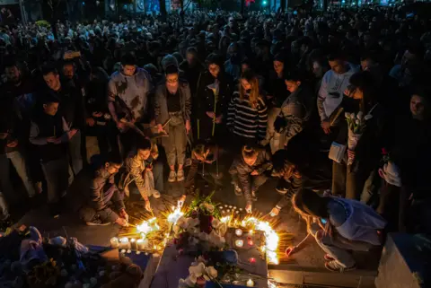 Srdjan Stevanovic/Getty Images People leave flowers and light candles near the Vladislav Ribnikar school in Belgrade, Serbia
