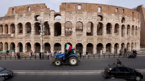 Reuters A tractor with an Italian flag attached to it drives past a Colosseum as farmers protest over price pressures, taxes and green regulation, grievances shared by farmers across Europe, in Rome, Italy