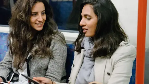 Getty Images Two women talking on the tube