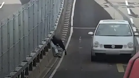 Man squeezes through central barrier