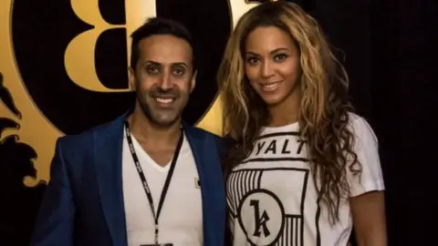Twitter Manni Hussain posing with Beyonce