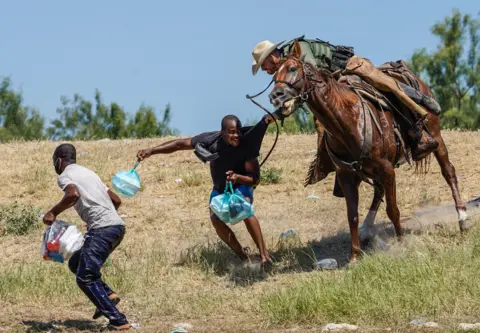 PAUL RATJE / afp A United States Border Patrol agent on horseback tries to stop a Haitian migrant from entering an encampment on the banks of the Rio Grande near the Acuna Del Rio International Bridge in Del Rio, Texas