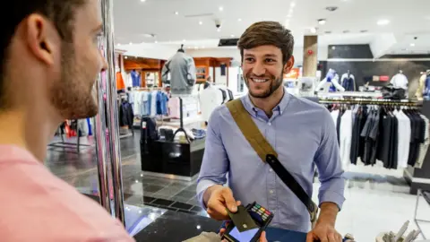 Getty Images Paying in a clothes shop