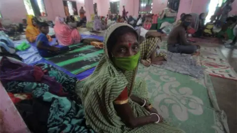 EPA Evacuated people sit in a temporary cyclone relief shelter as Cyclone Ampha