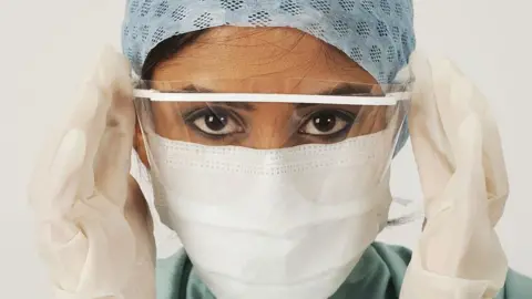 Getty Images Female medic in a mask