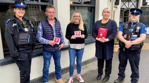 Essex Police Police and Julie Taylor outside a pub with a bleed kit