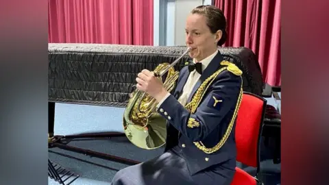 Crown Copyright 2022 Shona Brownlee playing the French horn in her RAF uniform