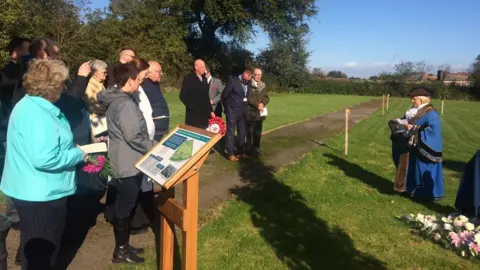People gathered at a cemetery
