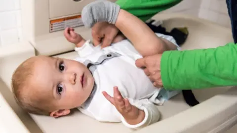 Getty Images Childminder changes nappy