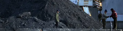 AFP North Korean labourers work beside the Yalu River at the North Korean town of Sinuiju on February 8, 2013 which is close to the Chinese city of Dandong. Piles of coal are seen.