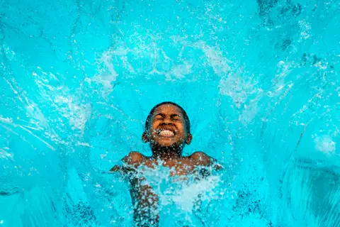 Victoria Jones/PA Wire A boy jumps into a swimming pool