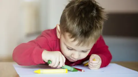 Getty Images Young boy colouring in paper