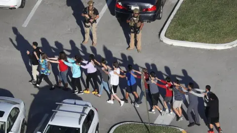 Getty Images High schoolers evacuate Marjory Stoneman Douglas High School