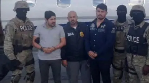 Handout photo of Efrain Antonio Campo Flores and Franqui Fancisco Flores de Freitas stand with Haitian law enforcement officers in this November 12, 2015 photo after their arrest in Port Au Prince, Haiti.