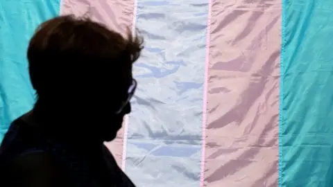 Getty Images Person walking past a trans flag