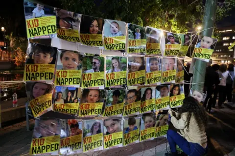 Getty Images Portraits of Israeli children hostages displayed at a rally in Tel Aviv