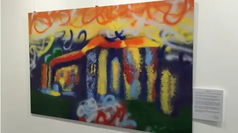 Colchester City Council An abstract painting hung on a wall next to an information card