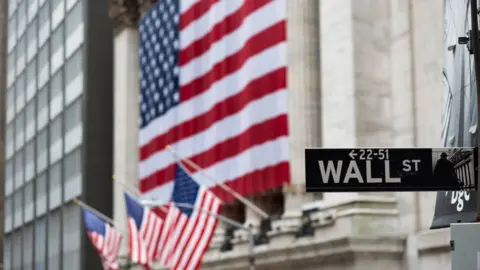 Getty Images US flags outside the New York Stock Exchange on Wall Street