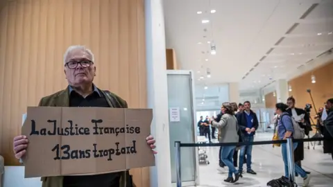 EPA A relative of victims of AF 447 holds a poster reading 'French Justice 13 years too late' on the first day of the trial