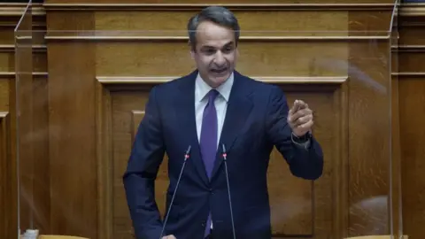 Getty Images Greek Prime Minister Kyriakos Mitsotakis addresses a parliament session in Athens on August 26, 2022