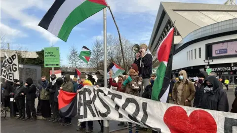 BBC Protesters holding up placards outside Bristol's Ashton Gate