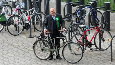 EPA/ROBERT PERRY Scottish Green co-leader Patrick Harvie holds his bike, while surrounded by other bikes