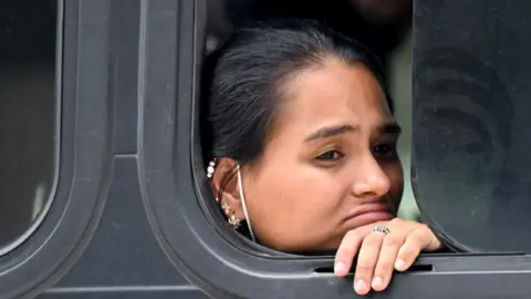 A woman part of a group of 81 migrants from Venezuela, Cuba, Haiti, Senegal, and Ghana sits on a bus after being detained by security forces and members of the Guatemalan Migration Institute in Guatemala City on September 28, 2022.