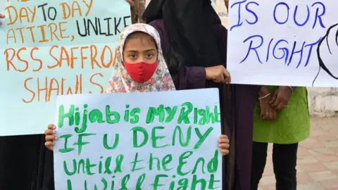 Muslim women hold placards during a demonstration after educational institutes in Karnataka denied entry to students for wearing hijabs, in Bangalore on February 7, 2022.