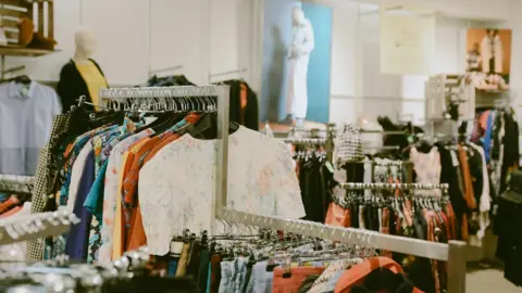 Charity Super.Mkt Clothes on racks in a store