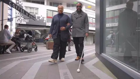 Sha Khan and someone aiding him through St Helier