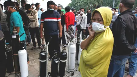 Getty Images West Java residents with oxygen canisters