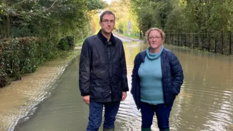 Green Party Adrian Ramsay with local councillor Lucy Elkin standing in flood water