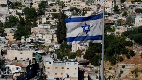 PAUL ADAMS An Israeli flag flies above East Jerusalem's Sheikh Jarrah neighbourhood
