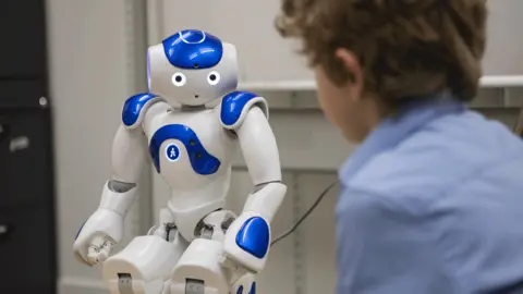 University of Plymouth Boy looking at a Nao robot