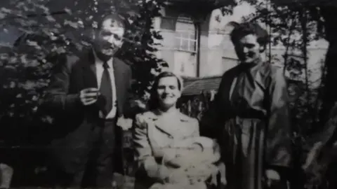 Anna Corrigan Baby Anna with her parents and her Godmother on her Christening day