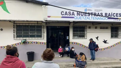 Megan Janetsky People wait outside a shelter for unaccompanied minors in Quetzaltenango, Guatemala