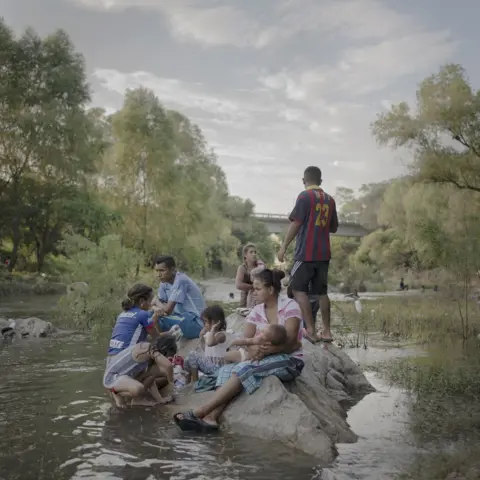 Pieter Ten Hoopen, Agence Vu/Civilian Act A family sit on a rock in a stream