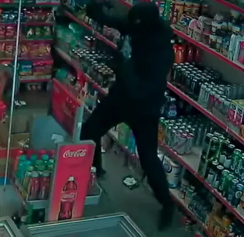 Met Police Person wearing dark clothing, a balaclava and gloves